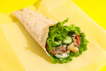 Tasty doner kebab on yellow background
