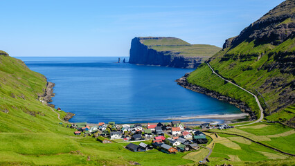 Nestled village along the serene fjord of the Faroe Islands under clear blue skies