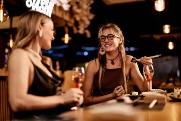 Two Women Enjoying Sushi Dinner in a Cozy Restaurant Setting
