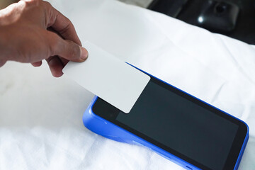 A white blank credit card shows NFC features. Financial technology concept.