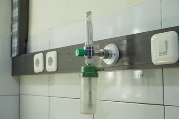 medical oxygen regulator installed on the wall of a patient's room in a hospital.