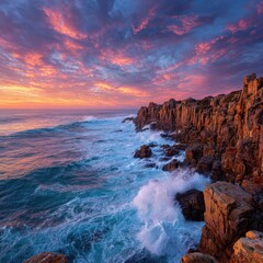 Fototapeta premium Coastal sunset scene with waves crashing against rugged cliffs. Vibrant sky