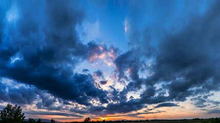 Dramatic sunrise and sunset sky with vibrant clouds, showcasing warm and cool color contrasts in a panoramic view.