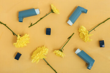 Modern inhalers with chrysanthemum flowers on yellow grunge background