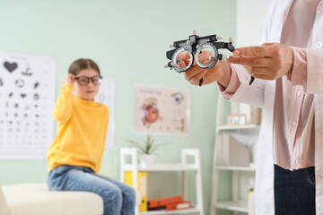 Female ophthalmologist with trial frame in clinic, closeup