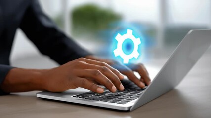 Hands engage with laptop, cogwheel overlay symbolizes tech innovation in digital workspace. Bright, modern environment promotes creativity and productivity