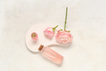Composition with bottle of cosmetic oil, plaster stand and roses on light grunge background