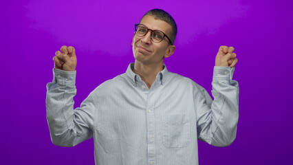 Caucasian man in glasses gesturing quotation marks on a vibrant purple background, isolated against...