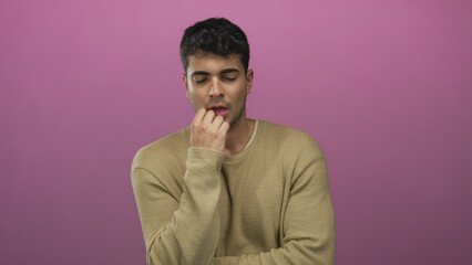 Man lowers head while sleeping against a colored background as a male hispanic young tired dozing...