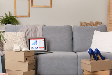New shoes from online store and laptop in interior of living room