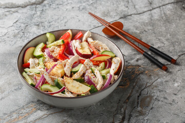Korean Cold Salad salad with chicken, cucumber, pepper and apple tossed with tangy sesame mustard dressing closeup on the plate on the table. Horizontal