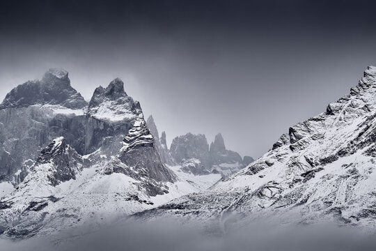 Winter fog twilight lanscape from Patagonia moutains with snow. Lago Nordenskjold, Torres del Paine National Park, Chile. Pink blue evening sky. Traveling in Chile,  hills in Torres del Paine NP.