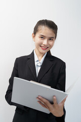 Portrait of Asian businesswoman standing reading documents in white studio background