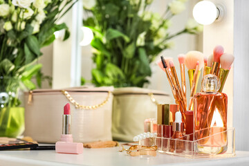 Decorative cosmetics with flowers on table in dressing room, closeup