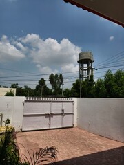 Residential Gate and Water Tower Under Blue Sky