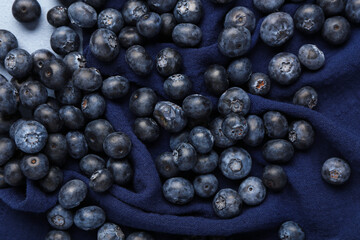 Sweet fresh blueberries on blue background, closeup
