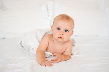 baby after bathing in a towel, baby hygiene, baby in a bath towel