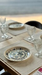 Elegant Table Setting with Blue and White Plates and Crystal Glasses in a Cozy Dining Room