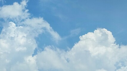 Blue sky with clouds. Blue sky with fluffy white cumulus clouds on a sunny day. The clouds were white and bright, creating a calm and peaceful atmosphere. Nature background.