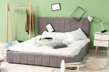 Interior of messy bedroom with frames and clothes rack