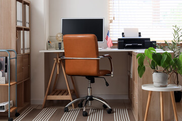Modern workplace with computer, USA flag and printer in office
