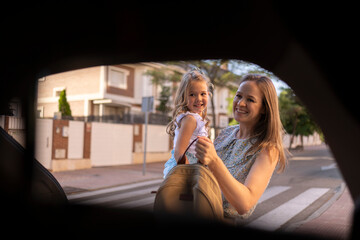 Mother and daughter smiling during morning school run by car