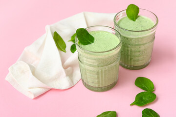 Glasses of fresh spinach smoothie on pink background