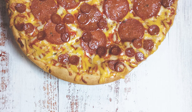 Pizza with a delicious double crust, pepperoni, and cheese, copy space. Close up and zenith view.