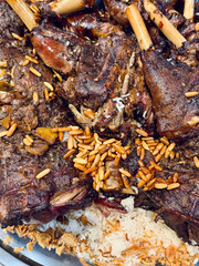 Roasted lamb on bed of rice garnished with pine nuts, closeup of traditional Arabic delicacy, festive Middle Eastern food platter