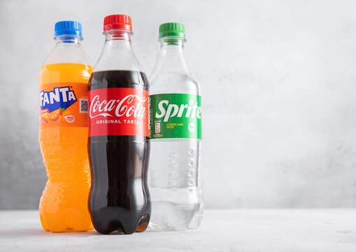 LONDON,UK - JUNE 28,2025: Bottles of Original Coca Cola and bottle of Sprite and fanta Orange soft soda drinks on light table background.