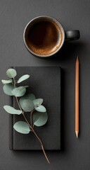 Dark coffee, journal, eucalyptus, and pencil