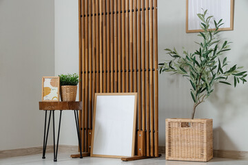 Stylish interior of living room with olive tree, coffee table, picture and folding screen