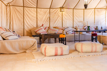 Boho lounge in luxury Moroccan Sahara desert tent with cozy seating
