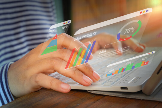 Typing with holographic analytics charts and graphs floating above. Ideal for business growth, data visualization, or financial technology content.