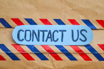 Fototapeta premium Note with text Contact Us on envelope background.