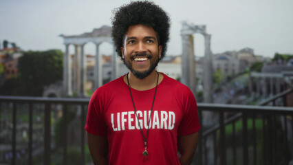 Smiling man in lifeguard shirt stands against backdrop of roman ruins on city street, embodying a...