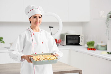 Female chef with apple pie recording cooking video class in kitchen