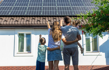 happy family on the background of a house with solar panels on the roof. Selective focus