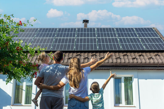happy family on the background of a house with solar panels on the roof. Selective focus
