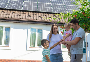 happy family on the background of a house with solar panels on the roof. Selective focus
