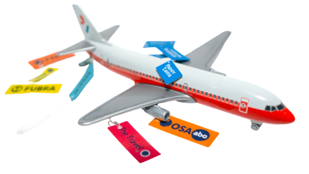 A toy airplane with attached company logo tags in various colors on a black background studio shot