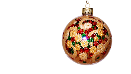 Ornate christmas ornament with gold swirls and red and green gems hanging on black background