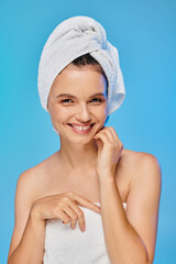 Vibrant woman with a towel on her head exuding joy and confidence in a serene setting
