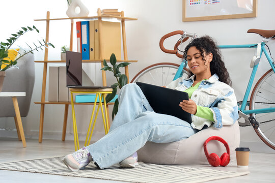 Female African-American web designer working with graphic tablet in office - Powered by Adobe