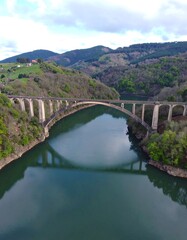 Arch bridge over calm river valley