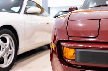 Detail view, from the right front corner of a red sports car with folding headlights, indicators....