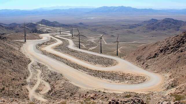 Winding road through a desert landscape with wind turbines - Powered by Adobe
