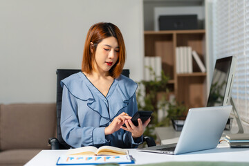 Female businessman working with holding a pen and using a calculator to calculate the numbers of...
