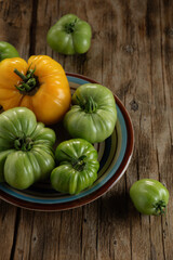 Freshly harvested heirloom tomatoes on a rustic wooden table displaying vibrant colors and unique shapes