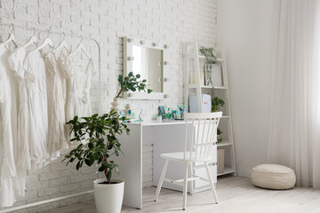 Interior of makeup room with table, clothes rack and shelf unit